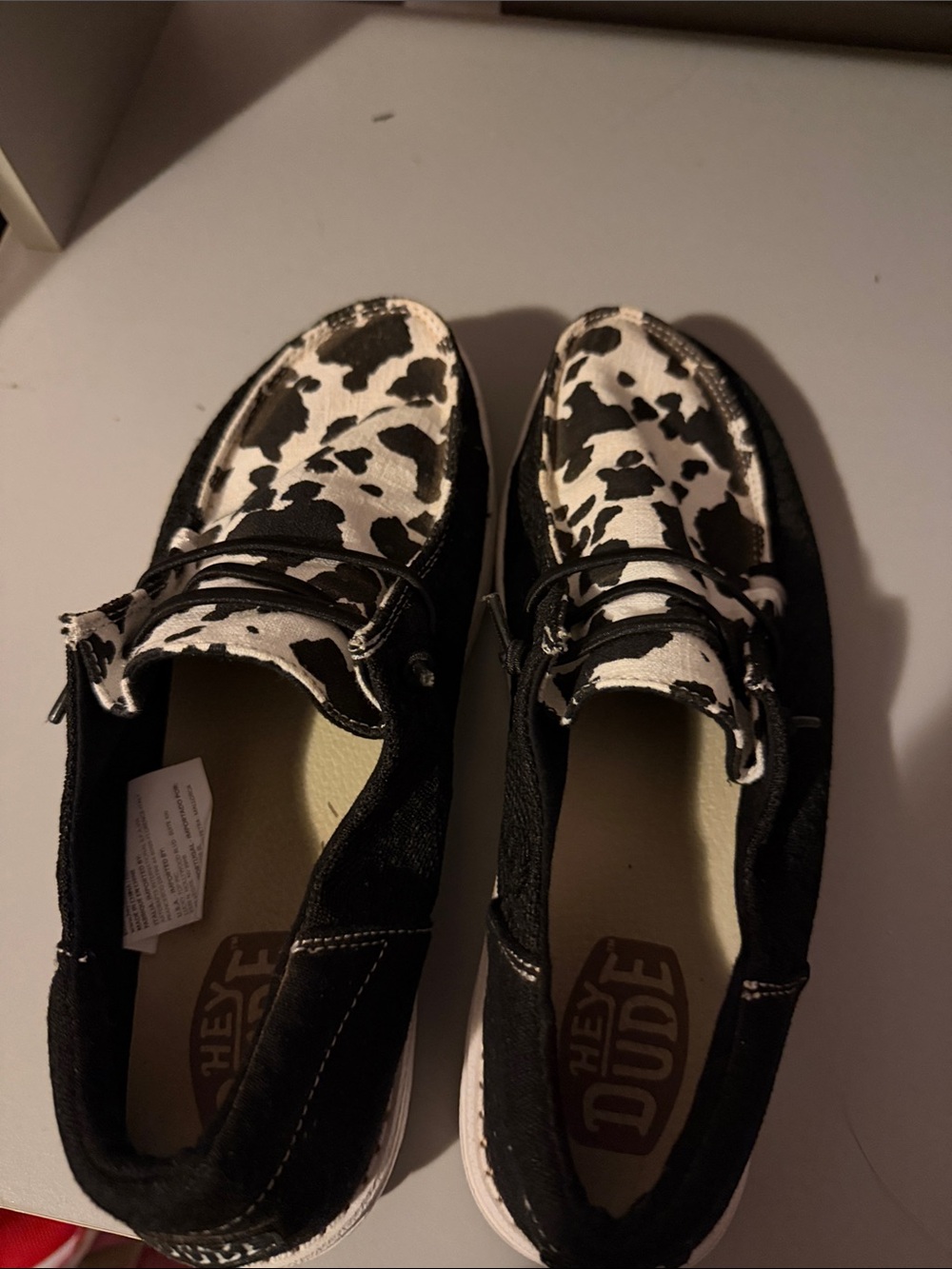 Hey Dude Black Canvas Slip-Ons with Cow Print Accents